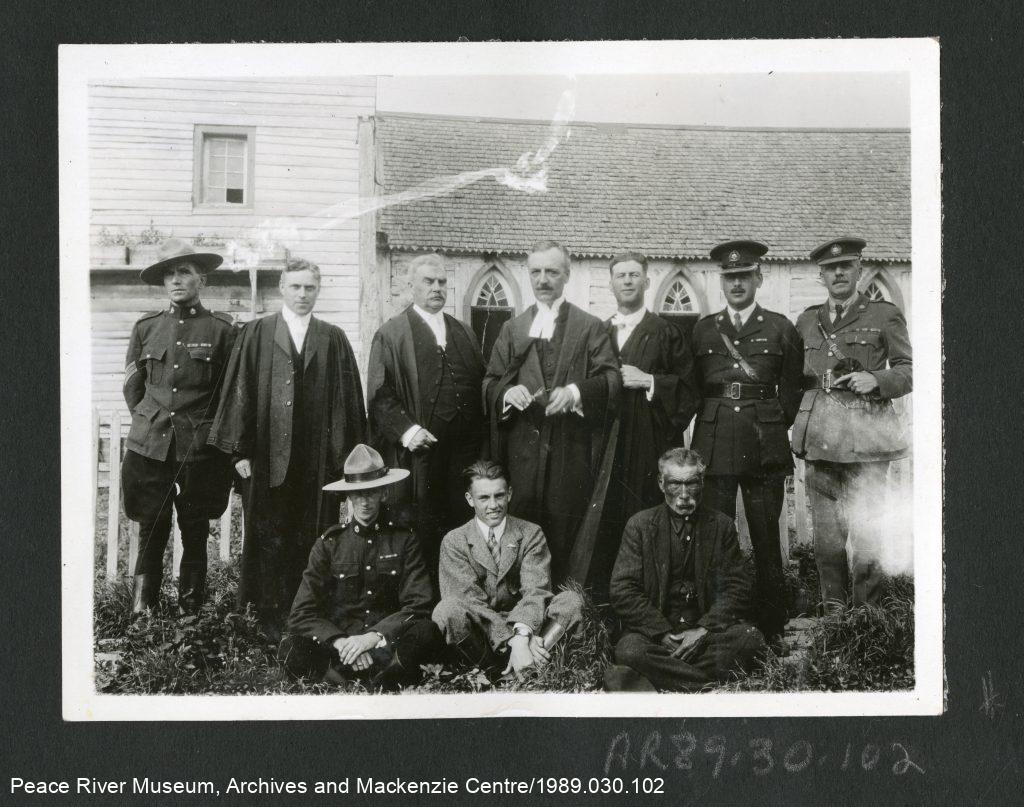 Membres du procès pour meurtre d’Albert LeBeau devant la mission catholique romaine à Fort Providence, le 29 juin ou le 30 juin 1921. La délégation du tribunal a voyagé avec les commissaires du Traité no 11 pour implanter aux TNO le droit tel que pratiqué dans le Sud du Canada.