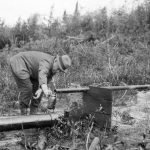 Le major D. L. Mckeand prélevant un échantillon de pétrole du puits de l’Imperial Oil à Fort Norman (maintenant Tulita), juin 1921. 