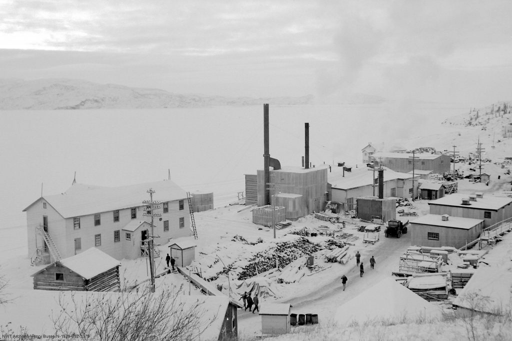 Cette photo montre le principal site minier de Port Radium. Des ouvriers marchent entre les bâtiments.