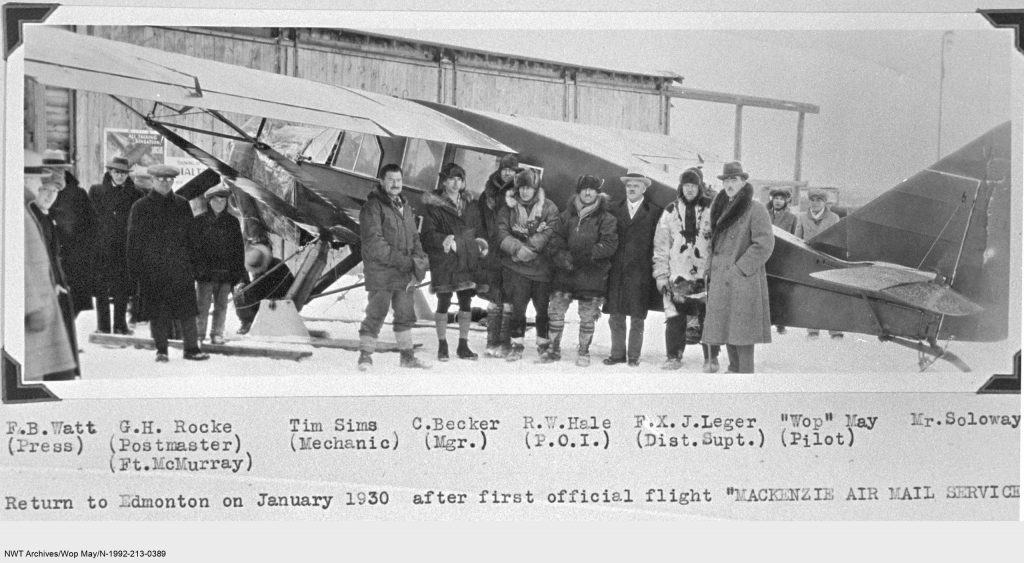 De retour à Edmonton après le premier vol officiel du service postal aérien Mackenzie, en janvier 1930. De gauche à droite: F.B. Watt (presse), G.H. Rocke (maître de poste, Ft. McMurray), Tim Sims (mécanicien), C. Becker (directeur), R.W. Hale (inspecteur principal des opérations), F.X.J. Leger (chef de district), « Wop » May (pilote), M. Soloway.