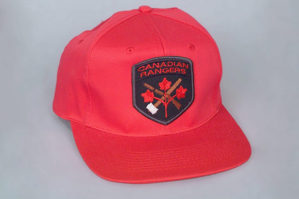 Reconnu dans tout le Nord, ce chapeau rouge muni d'un écusson symbolise les Rangers canadiens. L’écusson a été changé en 1996 et se lit maintenant comme suit : Canadian Rangers Canadiens. 