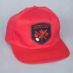 Reconnu dans tout le Nord, ce chapeau rouge muni d'un écusson symbolise les Rangers canadiens. L’écusson a été changé en 1996 et se lit maintenant comme suit : Canadian Rangers Canadiens. 