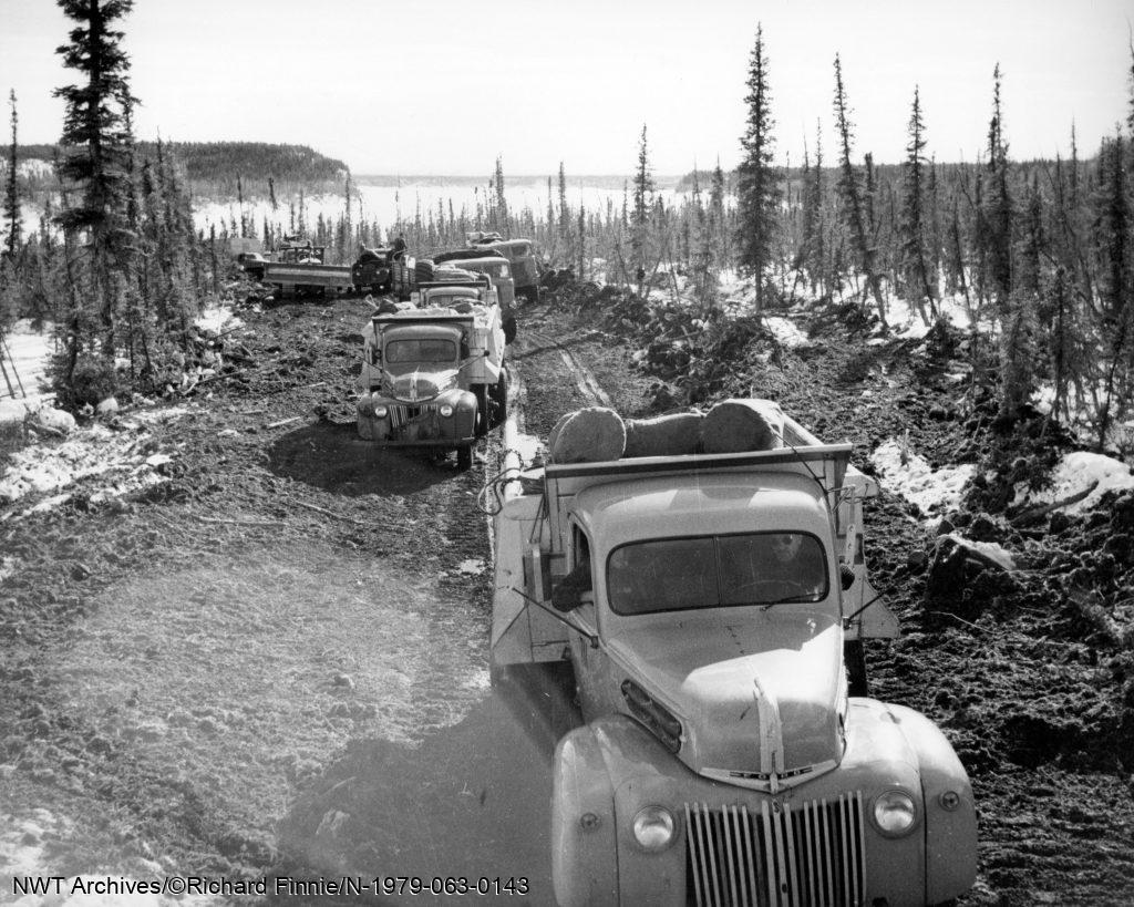Un convoi de camions et un bulldozer sur la rive nord de la Grande rivière de l’Ours après avoir traversé la glace depuis Fort Norman [maintenant Tulita], avril 1942. Ces véhicules étaient destinés à travailler sur le projet d’oléoduc CANOL.