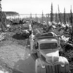 Un convoi de camions et un bulldozer sur la rive nord de la Grande rivière de l’Ours après avoir traversé la glace depuis Fort Norman [maintenant Tulita], avril 1942. Ces véhicules étaient destinés à travailler sur le projet d’oléoduc CANOL.