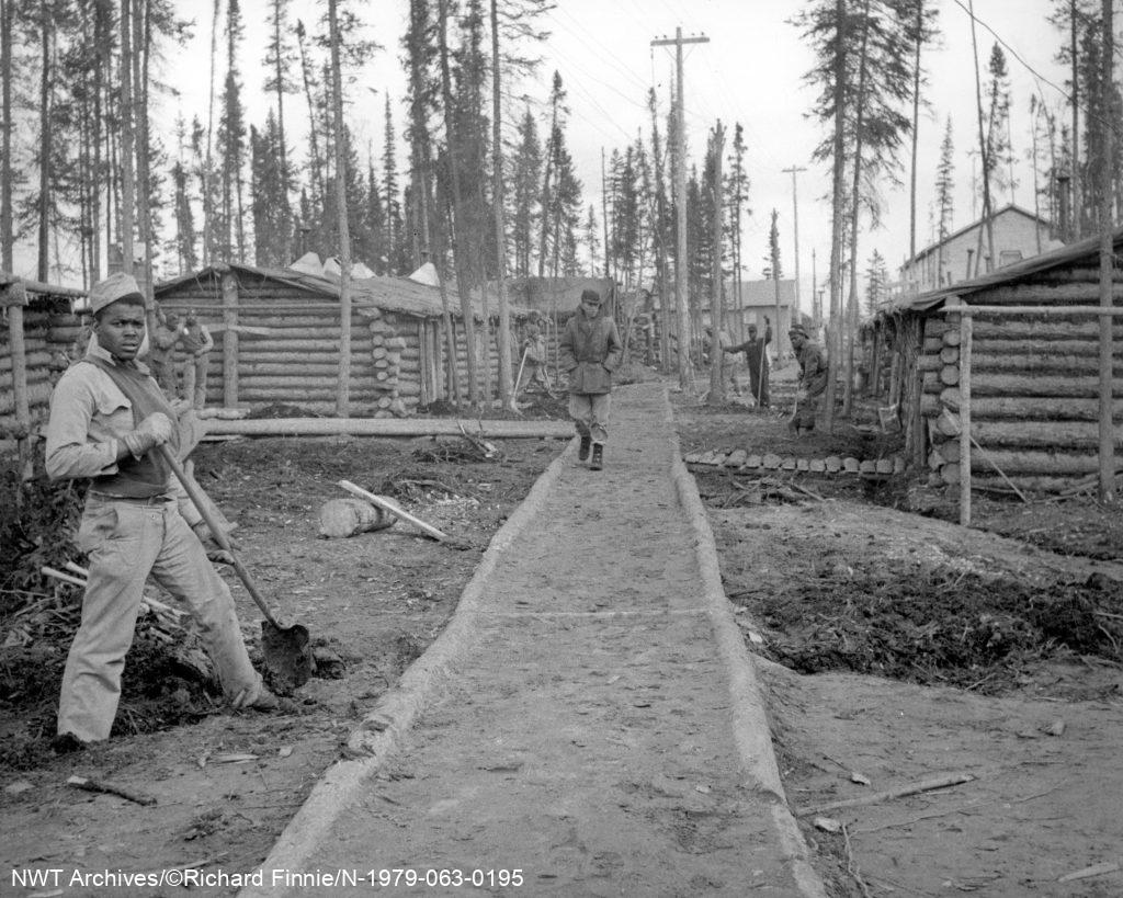 Quartiers pour le bataillon du génie américain au camp CANOL, 1943. Les troupes construisaient elles-mêmes les chalets en rondins. De nombreux hommes qui ont voyagé vers le Nord étaient des soldats noirs américains du sud des États-Unis.