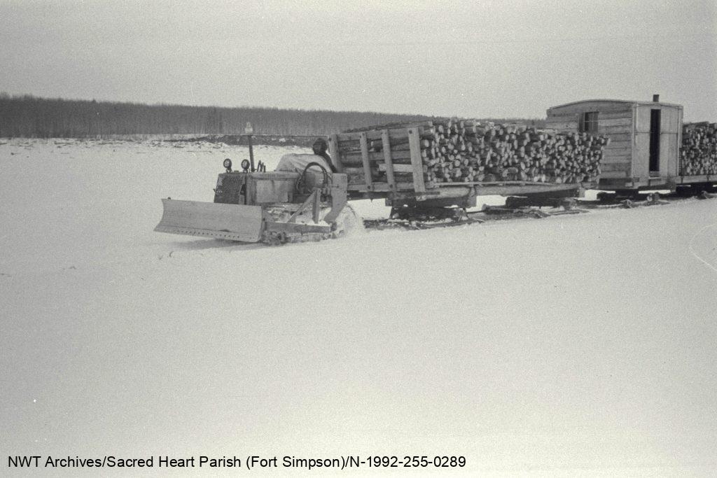 Un tracteur et un convoi de traîneaux remorquant du bois, Fort Simpson, années 1930.