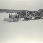 Un tracteur et un convoi de traîneaux remorquant du bois, Fort Simpson, années 1930.